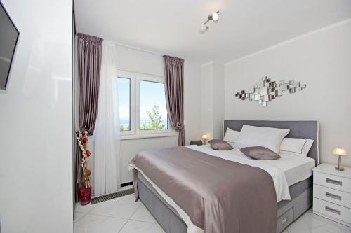 a bedroom with a large bed and a window at Villa Inis in Makarska
