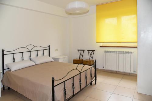 1 dormitorio con 1 cama grande y pared amarilla en Natour l'Ostello per i camminatori en Barisciano