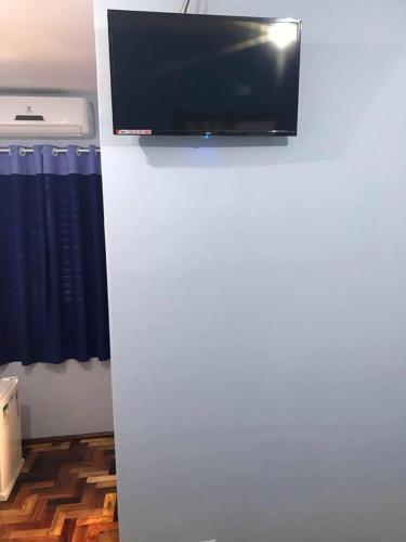 een flatscreen-tv op de top van een witte koelkast bij Ibiti Park Hotel in Ibitinga