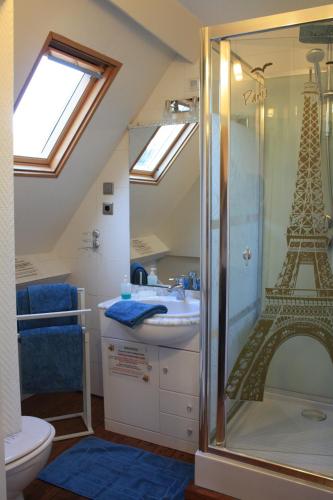 La salle de bains est pourvue d'une douche avec la tour Eiffel. dans l'établissement Logis Les Remparts, à Bayeux