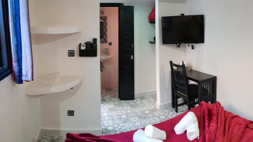 ein Schlafzimmer mit einem Bett und einem Waschbecken sowie einem TV in der Unterkunft Riad Africa in Marrakesch