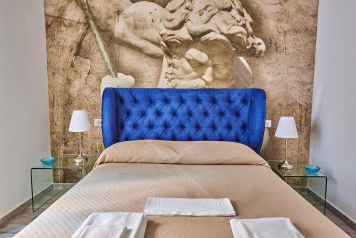 a bed with a blue headboard and a wall at Il Chiattillo in Naples