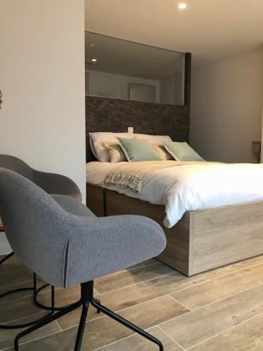 ミッデルケルケにあるVilla Novaのベッドルーム(ベッド1台、椅子、鏡付)