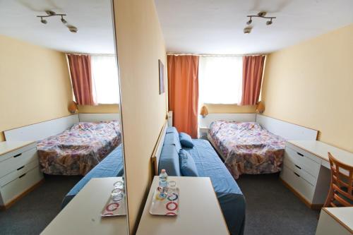 Habitación de hotel con 2 camas y espejo en Hostel Malinowski City, en Gliwice