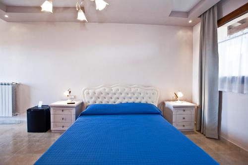 a bedroom with a blue bed and two night stands at Agriturismo Cannavota in Follonica