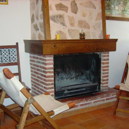 a rocking chair in front of a fireplace at El Corral Del Tio Emilio in Cuenca