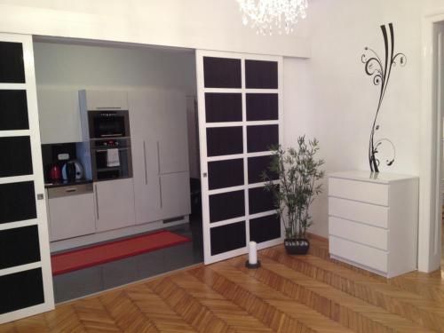 sala de estar con cocina con puerta corredera en Design Apartment Schönbrunn, en Viena