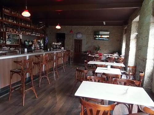 OutesにあるHostal Viñaのテーブルと椅子のあるレストラン、バー