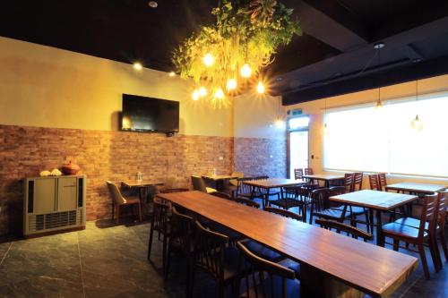a restaurant with tables and chairs and a tv on the wall at Two Home Inn in Hualien City