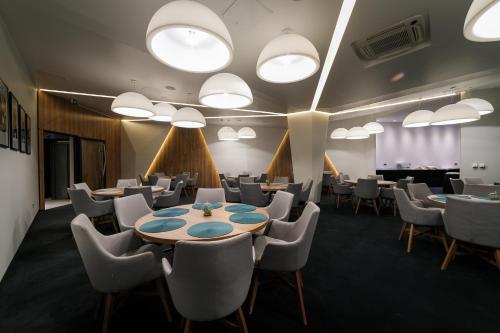 a conference room with tables and chairs and lights at Hotel Bank in Kiseljak