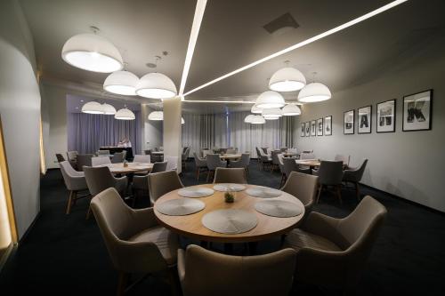 a dining room with tables and chairs and lights at Hotel Bank in Kiseljak
