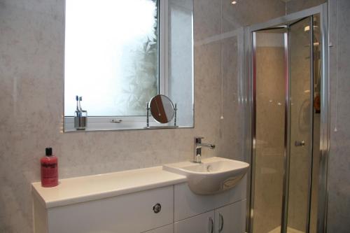 a bathroom with a sink and a mirror and a shower at Taigh An Clachair in Lybster