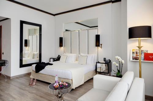 a bedroom with a white bed and a white couch at Meliá Milano in Milan