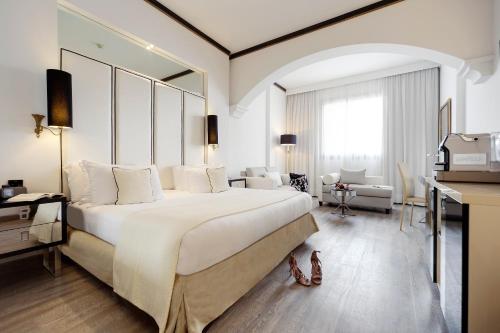 a hotel room with a large bed and a desk at Meliá Milano in Milan