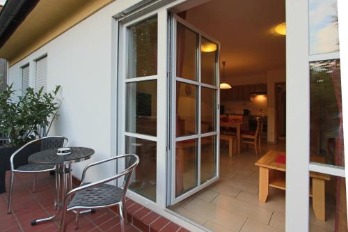 a patio with a glass door and chairs and a table at Döllelhof Erding in Erding