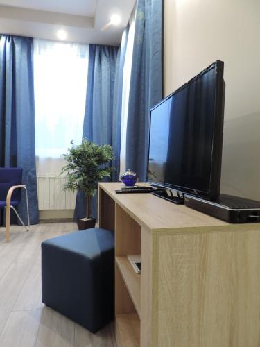 a living room with a television on a desk at Apartament Blue in Krosno