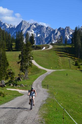 a person riding a bike down a dirt road at Pension Edelweiss Top21 in Gosau