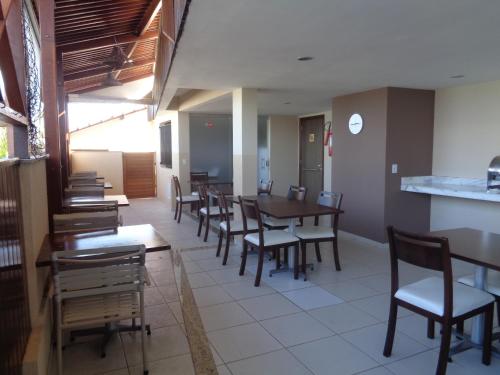 a dining room with wooden tables and chairs at Marsallis Praia Mar in Natal