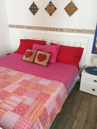 een slaapkamer met roze en oranje kussens op een bed bij Monolocale Santuzza in Mondello