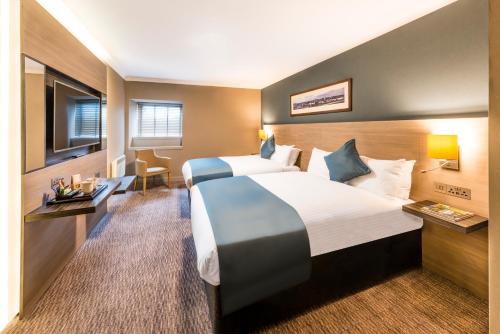 a hotel room with two beds and a television at Copthorne Aberdeen Hotel in Aberdeen