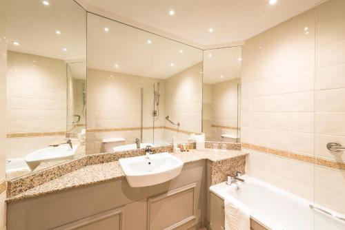 a bathroom with two sinks and a large mirror at Copthorne Aberdeen Hotel in Aberdeen