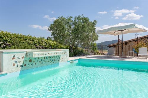 a large swimming pool with an umbrella and chairs at Agriturismo Dei Casali in Amelia