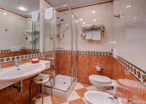 a bathroom with a shower and a toilet and a sink at Best Western City Hotel in Bologna
