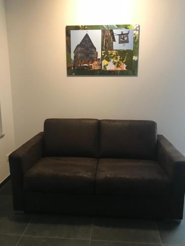 a brown couch in a room with a picture on the wall at Main Boarding House in Miltenberg