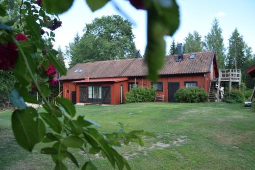 une maison rouge avec une cour devant elle dans l'établissement Björnåsen Bear Hill, à Katrineholm