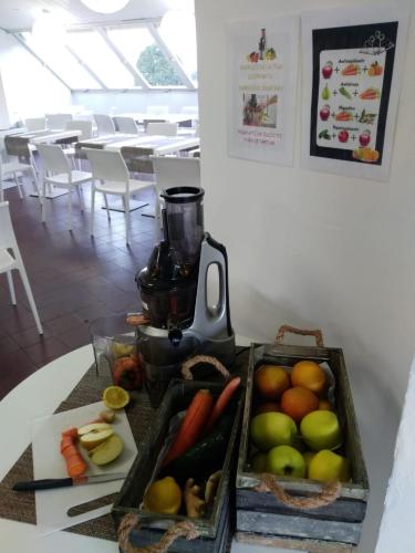 a tray of fruit and vegetables on a table with a juicer at Croce Bianca in Omegna