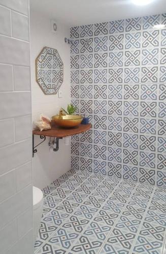 a bathroom with a blue and white tiled wall at Casa Martí in El Vendrell