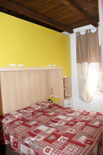 a bedroom with a bed and a yellow wall at Villa Panoramica Vista Mare Costa Rei 3 Camere da letto in Monte Nai