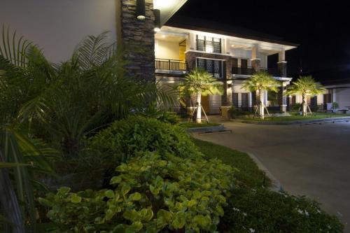 a hotel at night with palm trees and a building at Fortune Surin Hotel in Surin