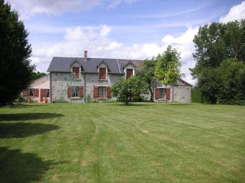 une vieille maison avec une aire de jeux dans la cour dans l'établissement Le lac aux fées, à Henrichemont