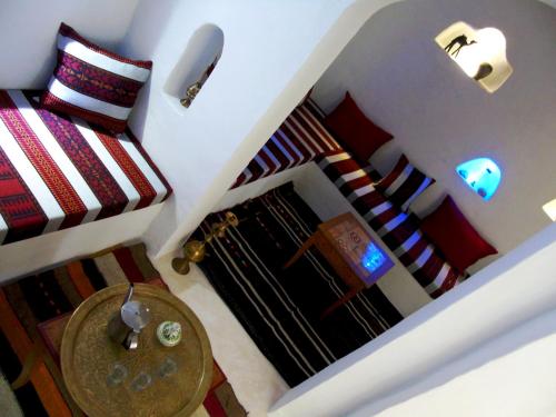 a room with two beds and a table at Dar Aladin in Arkou