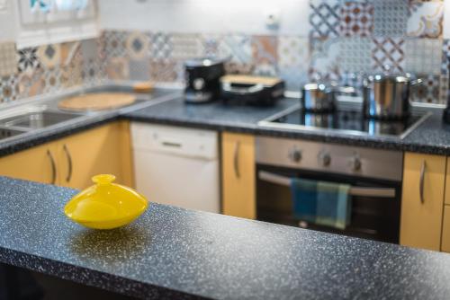a yellow bowl sitting on a counter in a kitchen at Splash of Glam II 10 Steps from Acropolis in Athens