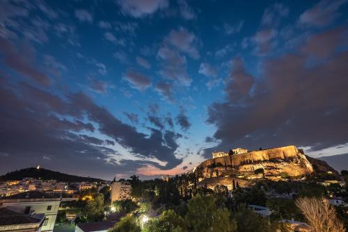 a castle on top of a mountain at night at Splash of Glam II 10 Steps from Acropolis in Athens