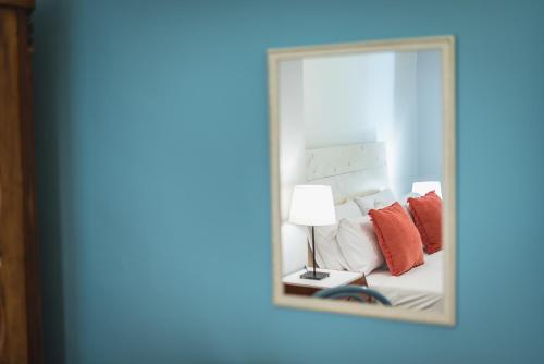 a mirror reflecting a bed with red pillows at Splash of Glam II 10 Steps from Acropolis in Athens