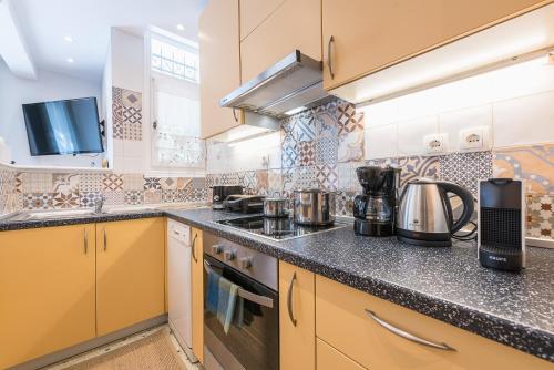 a large kitchen with yellow cabinets and appliances at Splash of Glam II 10 Steps from Acropolis in Athens