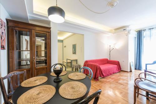 a living room with a table and chairs and a couch at Splash of Glam II 10 Steps from Acropolis in Athens