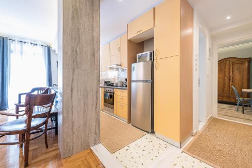 a kitchen with a stainless steel refrigerator and a table at Splash of Glam II 10 Steps from Acropolis in Athens