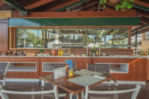 a restaurant with a table and chairs and a kitchen at PortBlue Club Pollentia Resort & Spa in Alcudia