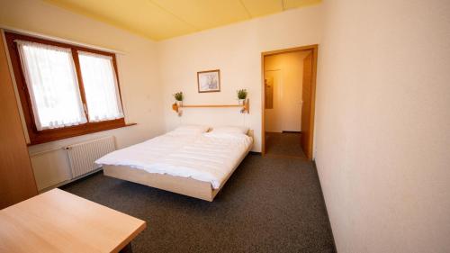 a bedroom with a white bed in a room at Sportchalet Mürren in Mürren