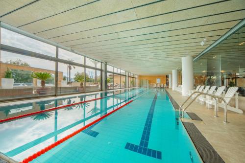 a large indoor swimming pool with a large amount of windows at PortBlue Club Pollentia Resort & Spa in Alcudia