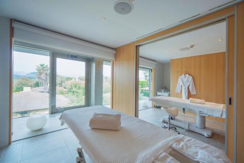 a bedroom with a bed and a bathroom with a window at PortBlue Club Pollentia Resort & Spa in Alcudia