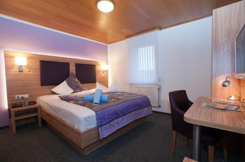 a bedroom with a bed and a desk and a table at Landgasthaus Bonn in Baunatal