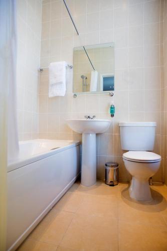 a bathroom with a sink and a toilet and a bath tub at Best Western Plus Nottingham Westminster Hotel in Nottingham