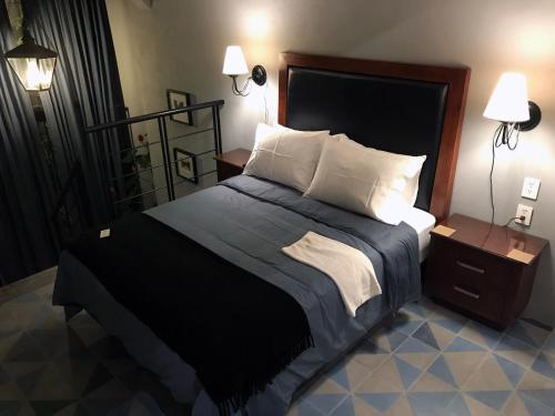 a bedroom with a large bed and two lamps at Colonia Americana Two Level Loft in Guadalajara