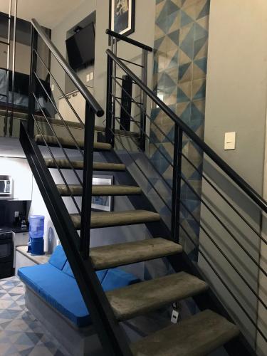 a staircase in a house with a blue seat at Colonia Americana Two Level Loft in Guadalajara