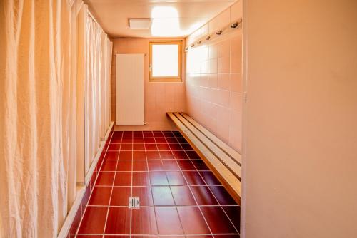 a hallway with a red tile floor and a window at Sportchalet Mürren in Mürren
